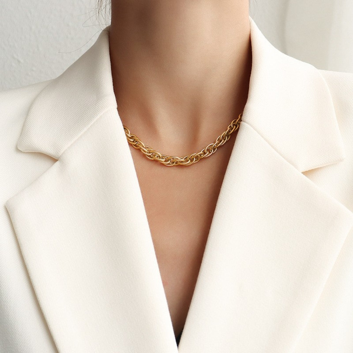 Titanium steel chain necklace, gold-plated, worn with white blazer.