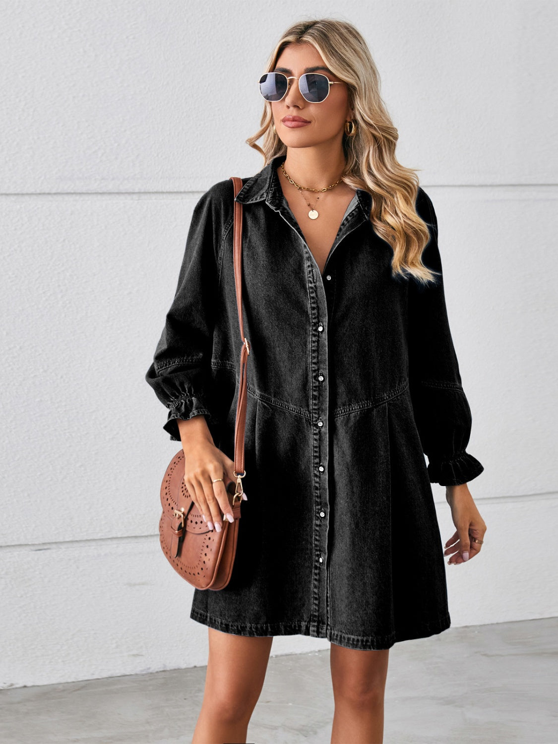 Flounce sleeve mini denim dress in black with button-up front, worn by model with a brown bag and sunglasses.