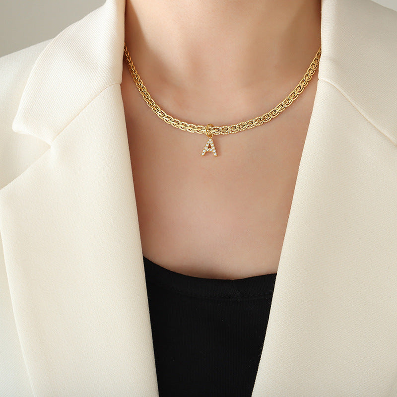 Brass Inlaid Zircon Letter Pendant Necklace on model wearing white blazer.